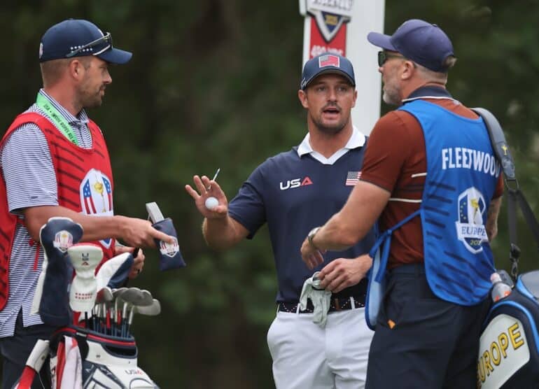 Bryson DeChambeau of Team United States gets in-between caddies Greg Bodine and Ian Finnis Photo by Michael Reaves/PGA of America