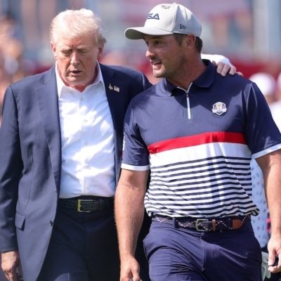 U.S. President Donald Trump speaks with Bryson DeChambeau o Photo by Andrew Redington / GETTY IMAGES NORTH AMERICA / Getty Images via AFP